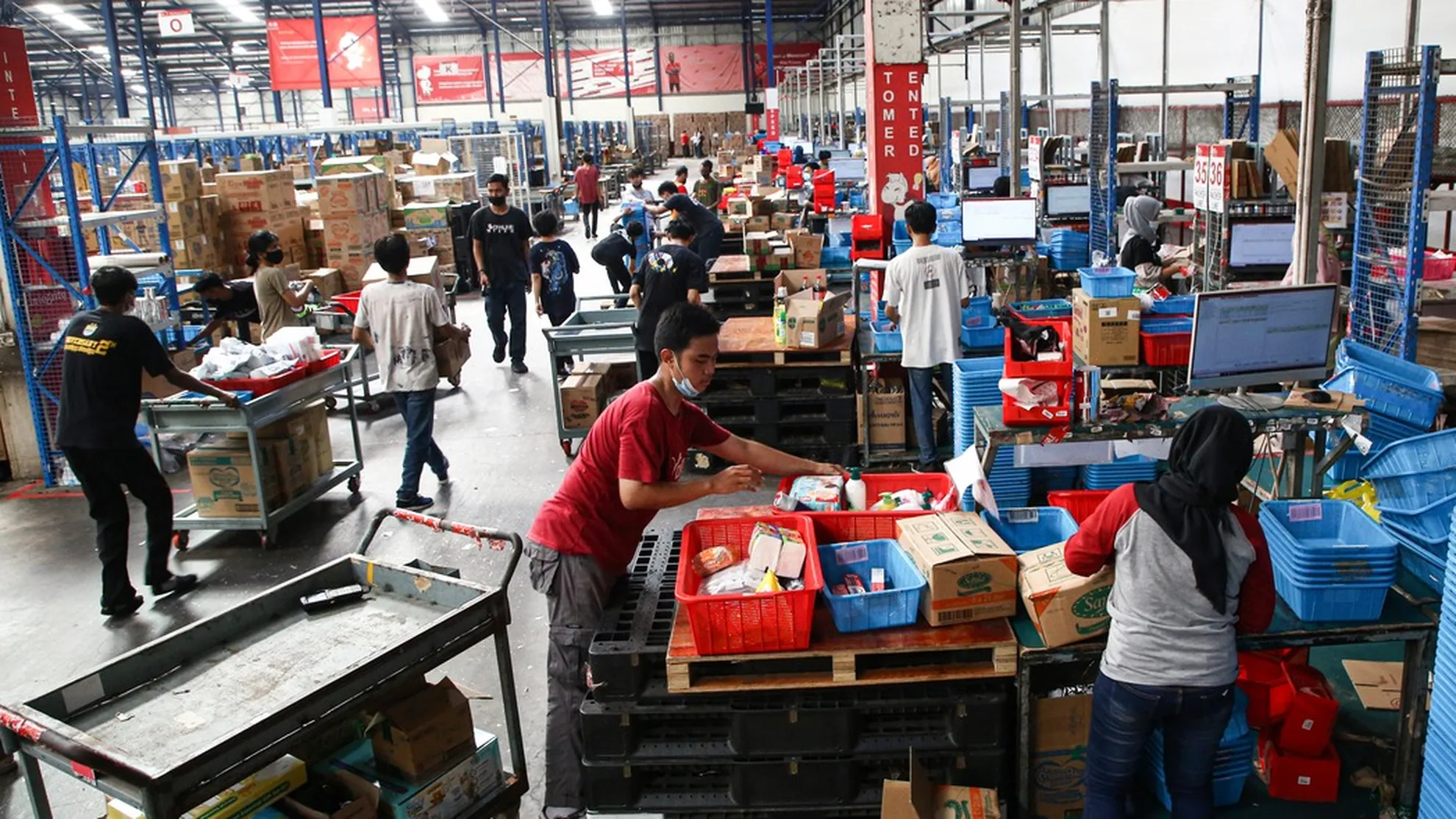 Aktivitas pekerja memproses pesanan di gudang marketplace terkait implementasi PMK 37/2025 tentang pemungutan PPh Pasal 22.