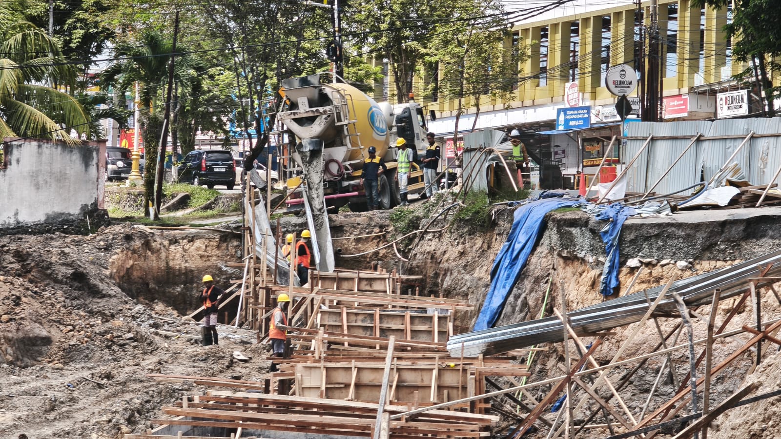 Pekerjaan perbaikan jalan longsor di Jalan Syafrudin Yoes Balikpapan menggunakan konstruksi fondasi permanen dengan truk mixer beton.