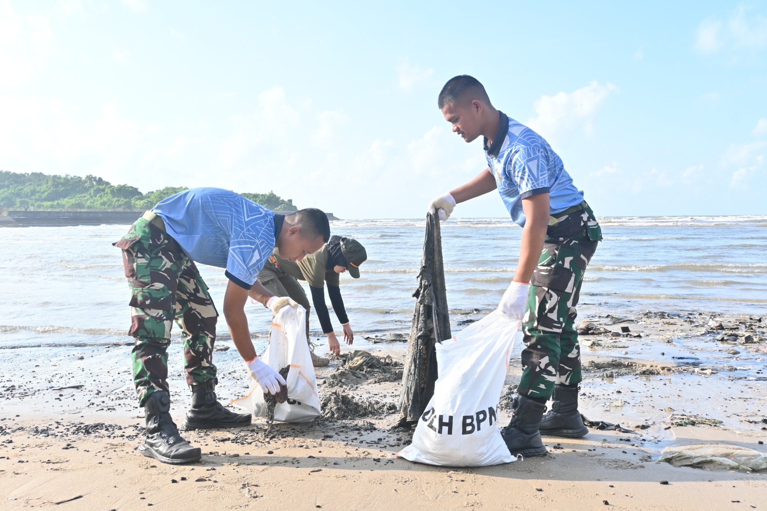 Personel Lanud Dhomber bersama peserta Gerakan Indonesia ASRI membersihkan sampah di Pantai Bandara Sepinggan, Balikpapan.