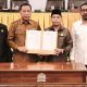 Sekretaris Daerah Balikpapan bersama pimpinan DPRD menunjukkan dokumen persetujuan Raperda Pertanggungjawaban APBD Tahun Anggaran 2025 usai Rapat Paripurna.