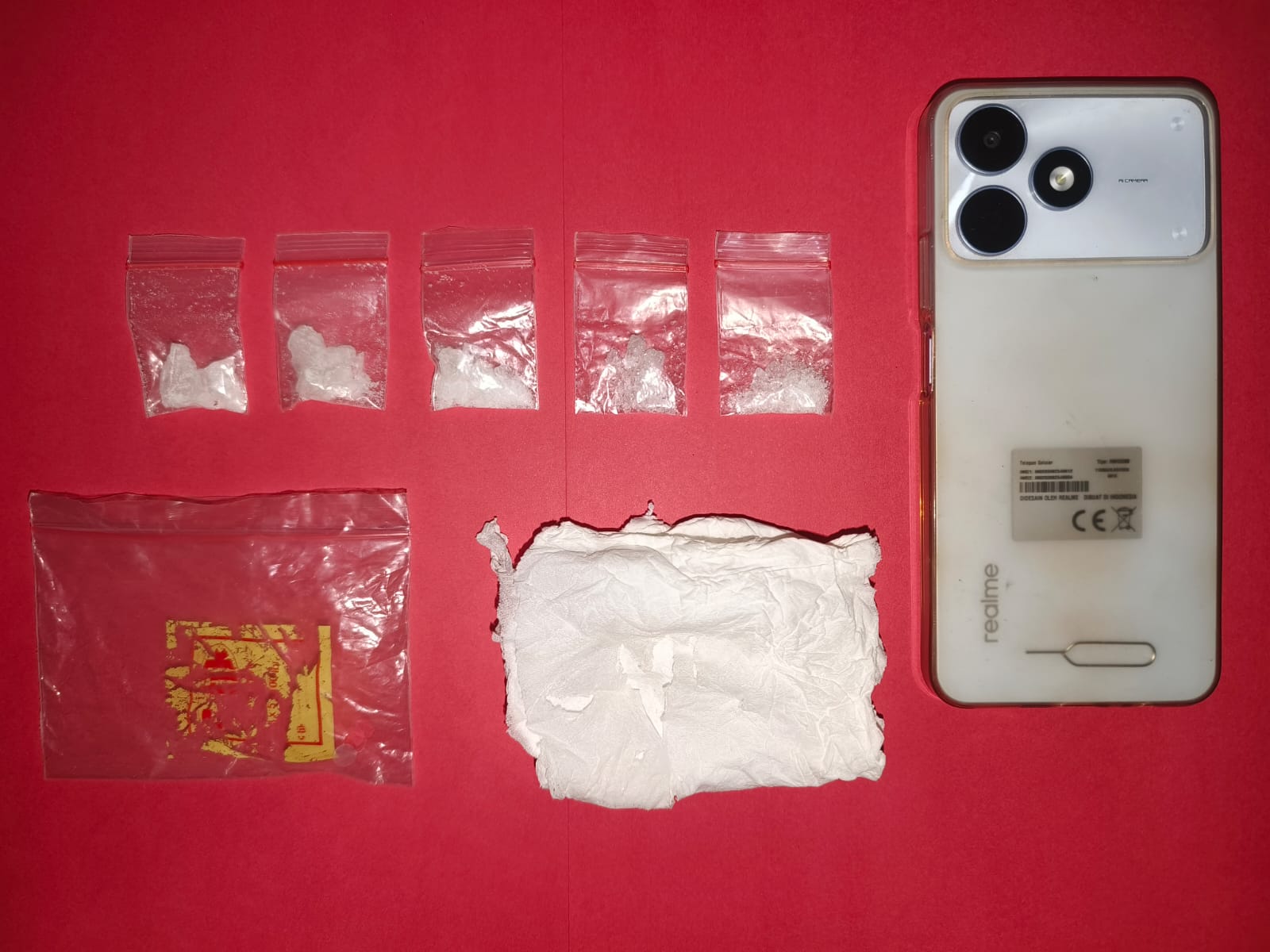 Barang bukti lima poket diduga sabu, telepon seluler, dan barang lain yang disita Polsek Biduk-Biduk dari seorang perempuan di Kampung Batu Putih, Berau.
