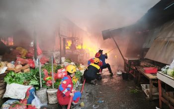 Petugas pemadam kebakaran memadamkan api yang melalap puluhan kios di Pasar Sepinggan, Balikpapan Selatan.