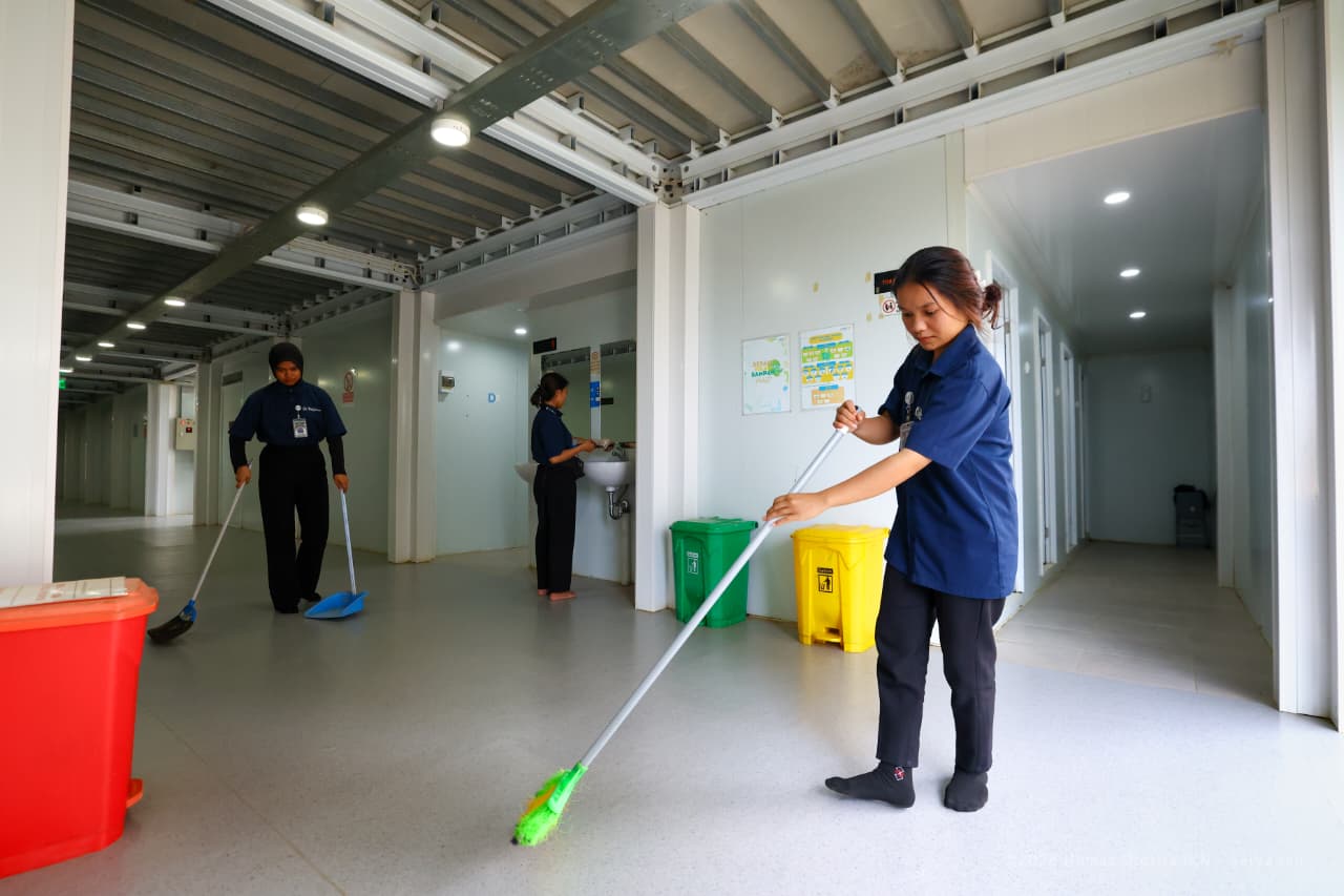 Petugas kebersihan membersihkan area Hunian Pekerja Konstruksi IKN yang dilengkapi sistem keamanan dan fasilitas responsif gender.